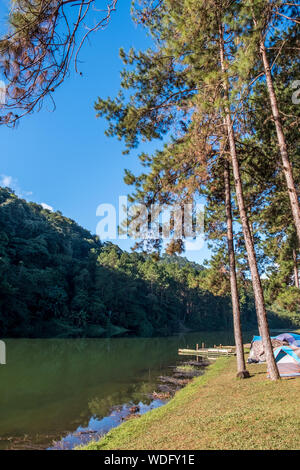 Camping field near the clear lake of the reservoir in the valley,Thai national park. Stock Photo
