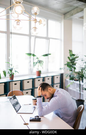 Tired student or businessman working with laptop in the office Stock Photo