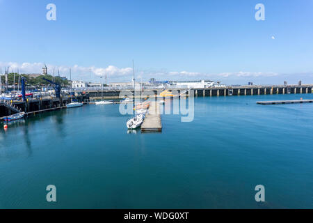 A scene in Dun Laoghaire Harbour with small yachts moored at a pontoon and the RNLI lifeboat in the background. Stock Photo