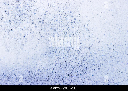 White bubble of detergent in blue container for background. Abstract texture. Stock Photo