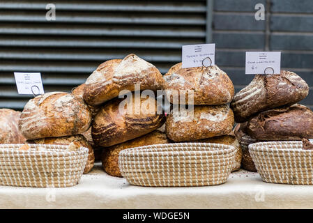 Display of rustic loaves in street market. Stock Photo