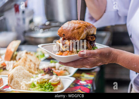 Dirty burger being served at a street food market Stock Photo