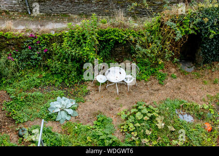 Table and chairs in a green garden Stock Photo