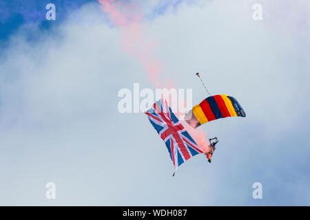 Bournemouth, UK. 29th August 2019. Up to a million people are set to descend on Bournemouth over the next four days as the 12th annual Bournemouth Air Festival gets underway. Tigers Freefall Parachute Display Team. Parachutist flying the Union Jack flag against blue sky.  Credit: Carolyn Jenkins/Alamy Live News Stock Photo
