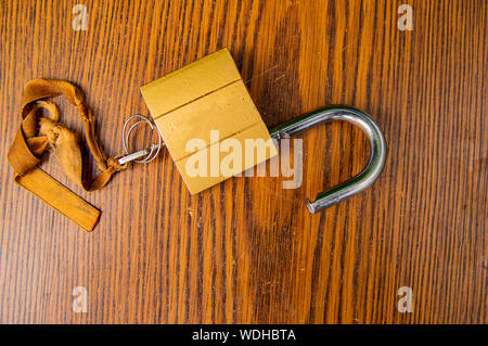 Padlock with key on the tape on a wooden background. Place for text. Stock Photo