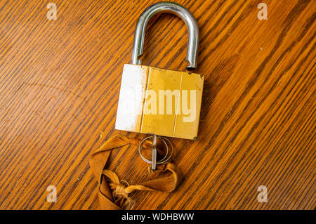 Padlock with key on the tape on a wooden background. Place for text. Stock Photo