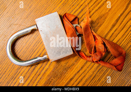 Padlock with key on the tape on a wooden background. Place for text. Stock Photo