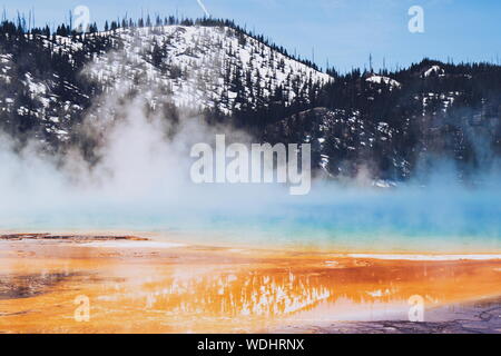 Grand Prismatic Spring By Snow Covered Mountains At Yellowstone National Park