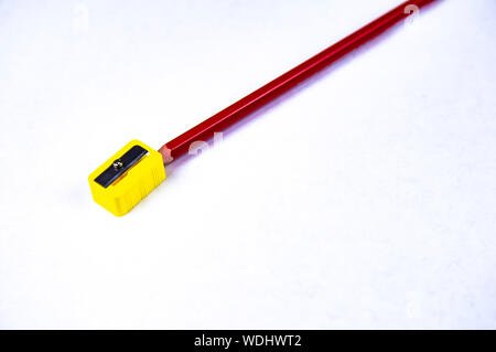 Multi-colored pencils for drawing with a sharpener on a white background. School. Background. Place for text. Stock Photo