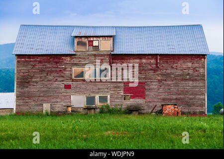 Old weathered barn with peeling red paint in Stowe, Vermont, USA Stock Photo