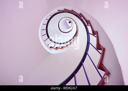 Spiral staircase viewed from below forming circular geometric pattern Stock Photo
