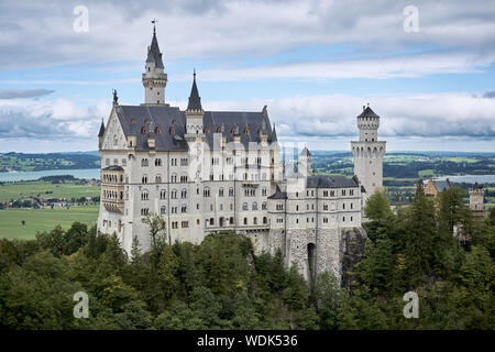View of the famous tourist attraction in the Bavarian Alps - the Neuschwanstein castle infront of blue sky and nature / 2019 Stock Photo