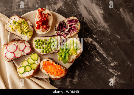 Brushetta or traditional spanish tapas. Appetizers italian antipasti snacks set on wooden board. Top view and flat lay with space for your text Stock Photo