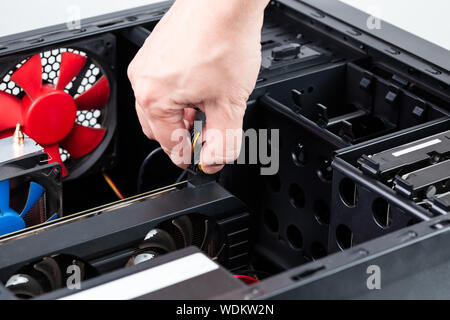 hand plugging aux power connector to the video card while maintenance personal computer hardware with selective focus closeup Stock Photo