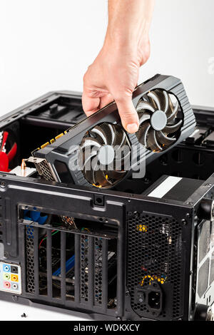 hand plugging a video card while maintenance personal computer hardware with selective focus closeup Stock Photo