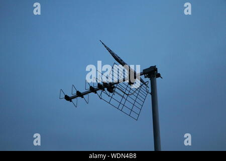 antenna tv on a roof on a blue sky background Stock Photo