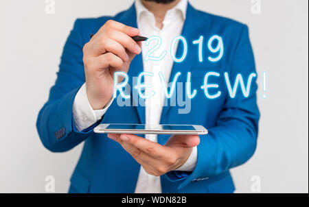 Handwriting text writing 2019 Review. Conceptual photo remembering past year events main actions or good shows Businessman with pointing finger in fro Stock Photo