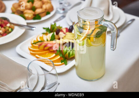 Carafe with delicious cool lemonade stands on a table in a restaurant Stock Photo