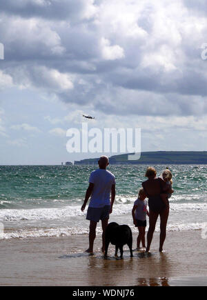 Bournemouth, UK. 29th Aug, 2019. People on the beach watch a Lancaster Bomber at the Bournemouth Air Show, Dorset, on August 28, 2019. Credit: Paul Marriott/Alamy Live News Stock Photo