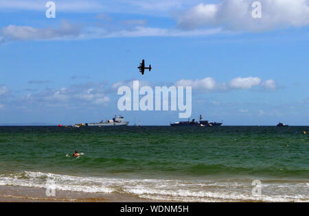 Bournemouth, UK. 29th Aug, 2019. A Lancaster Bomber passes over two Royal Naval war ships at the Bournemouth Air Show, Dorset, on August 28, 2019. Credit: Paul Marriott/Alamy Live News Stock Photo