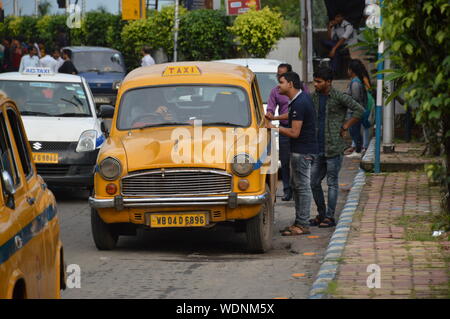 Kolkata, India. 29th Aug, 2019. People are talking with a yellow taxi driver for a ride. (Photo by Biswarup Ganguly/Pacific Press) Credit: Pacific Press Agency/Alamy Live News Stock Photo