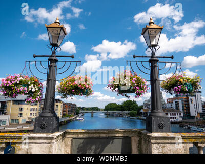 Ornamental flowers and medieval lamps on the wall of Kingston bridge in a sunny day Stock Photo