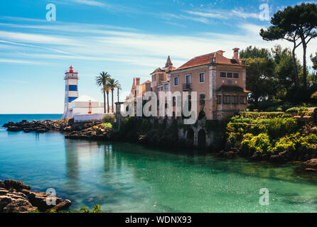 View of Santa Marta lighthouse and Municipal museum of Cascais, Portugal with bright green water from a stream flowing into the Atlantic ocean Stock Photo