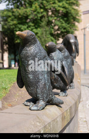 A Sculpture of 5 Penguins Walking in Single-File Outside St Mary's Church in Dundee's City Centre Stock Photo