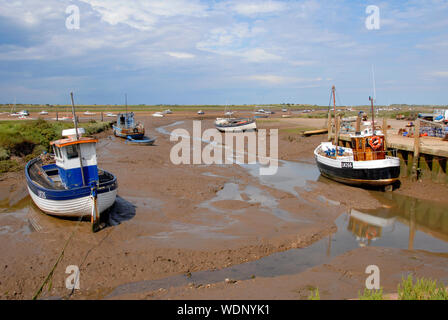 Boats on the mud at low tide, Brancaster Staithe, Norfolk, England Stock Photo
