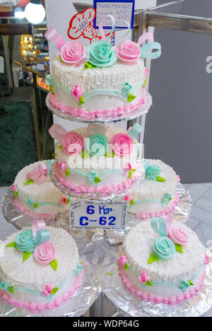 White wedding cakes with red and green roses at PAS ELERIA IDEAL, a local bakery, mexico city, mexico Stock Photo