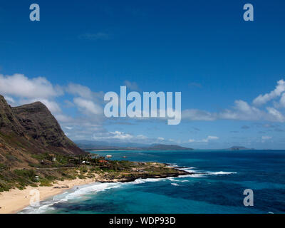 Waves crash on Makapuu Beach with the Koolau Range Mountains above looking towards Waimanalo Bay on the Windward coast of Oahu, Hawaii. Stock Photo