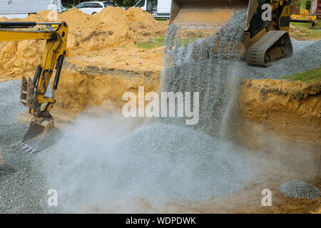 A bulldozer on wheels buried a excavator bucket working on the building under construction excavator extracting stone Stock Photo