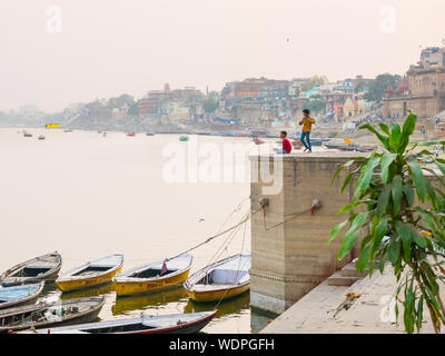 Two young Indian boys flying kites on the edge of the Ganges River in Varanasi, Uttar Pradesh, India, Asia Stock Photo