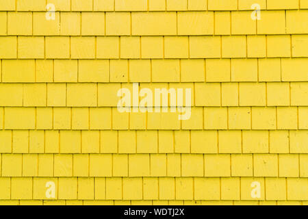 Exterior wall with bright yellow shingles Stock Photo