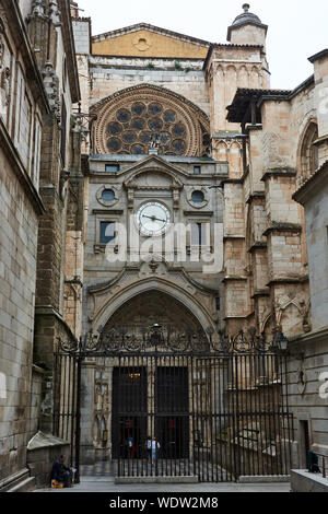TOLEDO, SPAIN - APRIL 24, 2018: A narrow medieval street leads to the Portal of the Clock, one of the gates of the Primate Cathedral of Saint Mary of Stock Photo