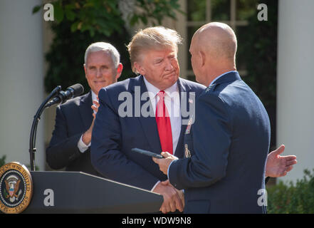 Washington DC, USA. 29th Aug, 2019. General John W. 'Jay' Raymond, Commander, Air Force Space Command, right, presents a momento to United States President Donald J. Trump, center, at the ceremony establishing the US Space Command in the Rose Garden of the White House in Washington, DC on Thursday, August 29, 2019. The Space Command will be the lead military agency for the planning and execution of space operations and will be a step towards establishing a Space Force as a new military service. US Vice President Mike Pence applauds at left.Credit: Ron Sachs/Pool via CNP/MediaPunch Credit: Medi Stock Photo