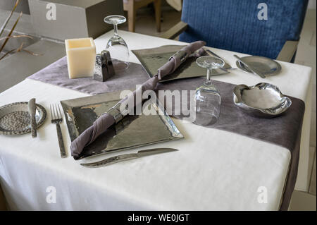 Dining stainless set with cutlery, plate, wine glass on tablecloth Stock Photo
