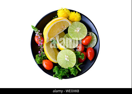 Variety fruits of Lemon, Lime, Tomato and Parsley in a bowl. Isolated on white background Stock Photo