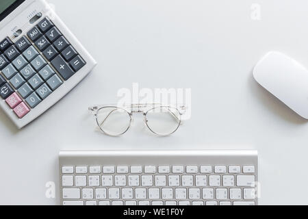 High Angle View Of Calculator By Eyeglasses With Computer Keyboard And Mouse On White Background