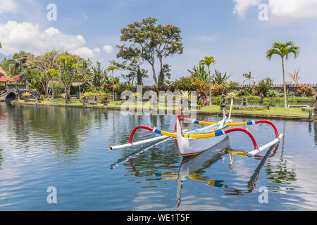 Traditional Balinese fishing boat in the pond of the Taman Tirta Gangga water palace in Karangasem, Indonesia Stock Photo