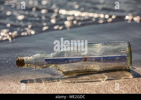 message in a bottle on the beach Stock Photo