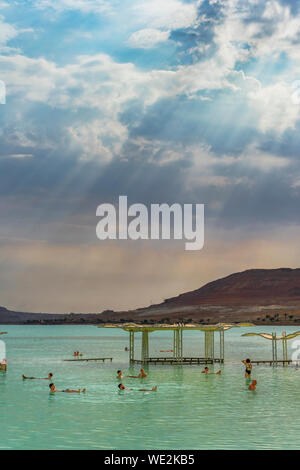 Holiday makers in the green waters of the Dead sea, Israel Stock Photo