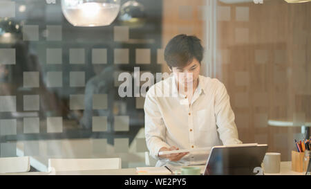 Professional male freelancer working on his strategy for the next project in modern workplace Stock Photo