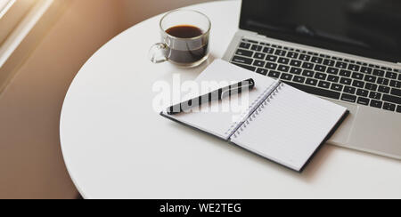 Open laptop computer with office supplies on white wooden table in comfortable workplace Stock Photo