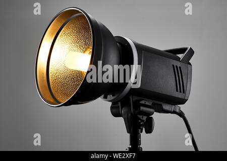 Brand new photography studio flash head turned on in a photo studio environment. Stock Photo