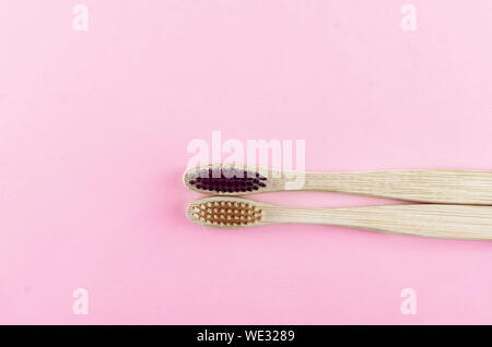 two wooden eco brushes with natural bristles on pink paper background. Plastic free set. Zero waste, eco friendly concept. Stock Photo