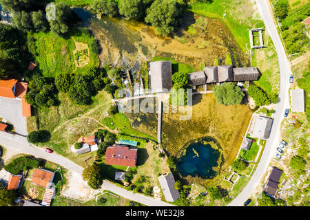 Croatia, region of Lika, Majerovo vrilo river source of Gacka, traditional village, old wooden mills and cottages aerial drone view Stock Photo