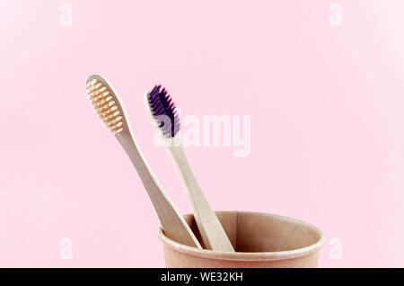 two wooden eco brushes with natural bristles on pink paper background. Plastic free set. Zero waste, eco friendly concept. Stock Photo