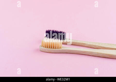 two wooden eco brushes with natural bristles on pink paper background. Plastic free set. Zero waste, eco friendly concept. Stock Photo