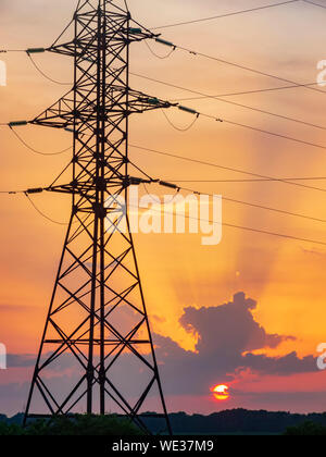 Power lines support tower at sunset. Environment and industry Stock Photo
